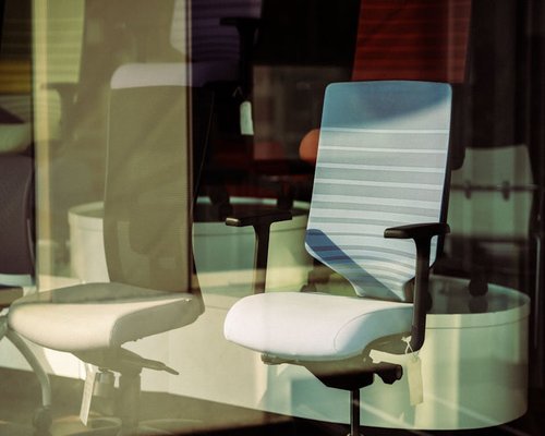 A well-lit, ergonomically balanced home office setup showcasing a chair with lumbar support
