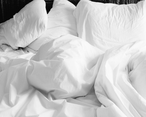 A serene bedroom setting with soft, natural fabrics and subtle lighting favoring high quality sleep